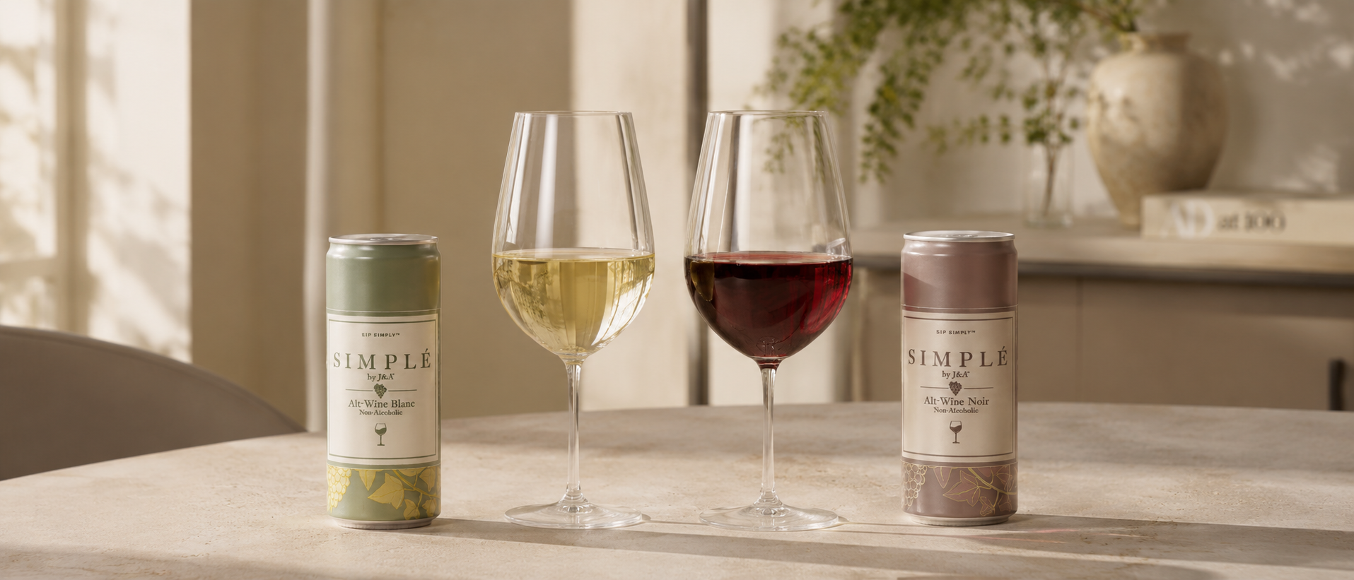 Two wine glasses with white and red wine, accompanied by 'Simple' wine bottles on a table.